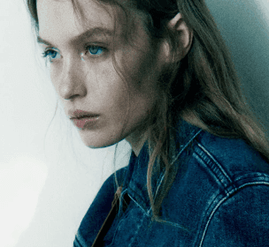 a woman with long hair wearing a denim jacket